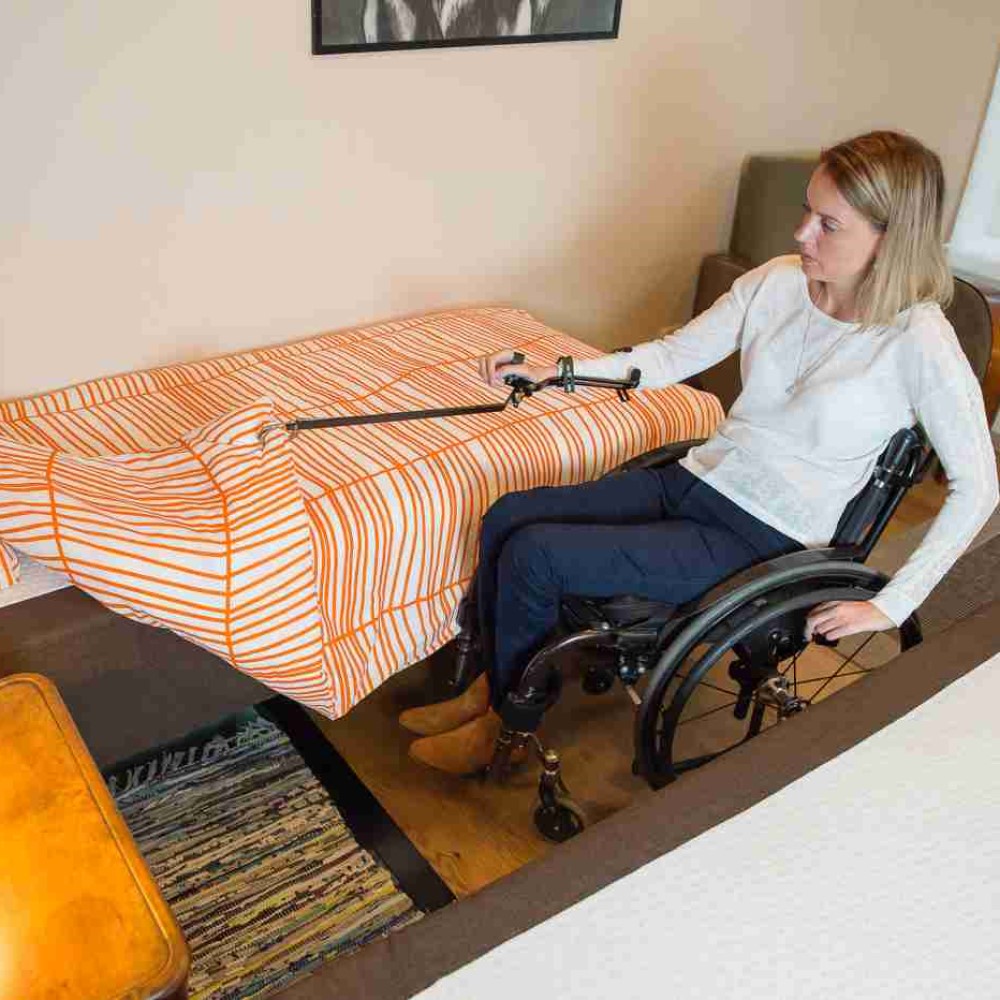 Reacher/ grabber woman making bed. Suitable for reduced hand function: tetra, quad, cerebral palsy, SCI, spinal cord injury, stroke and more.