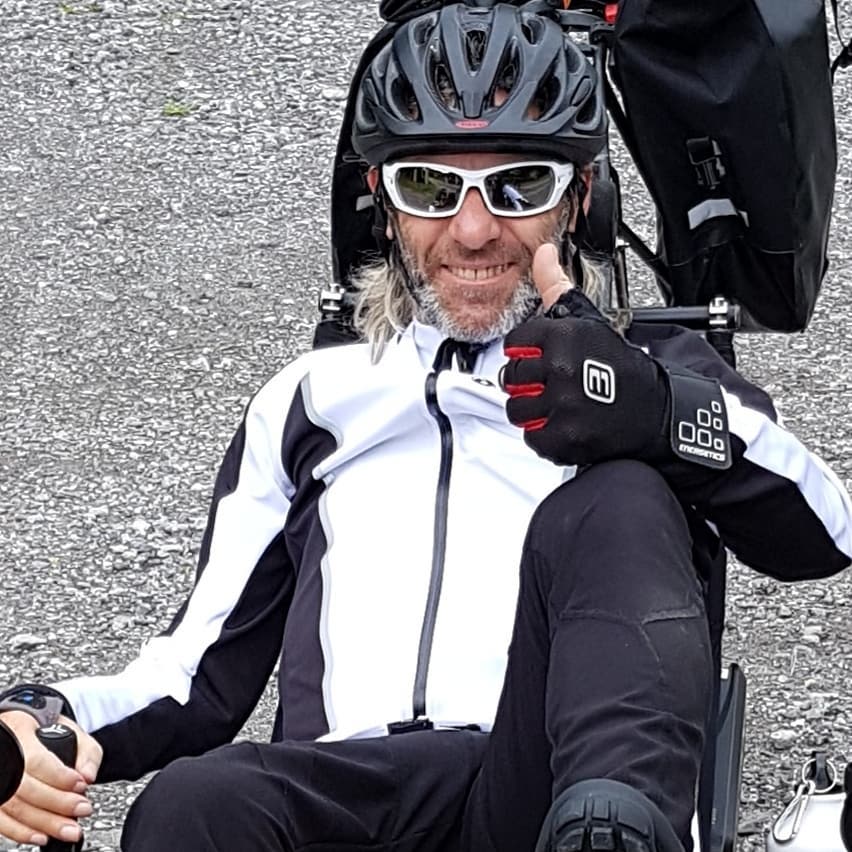 Man gives a thumbs up from his recumbent bike.