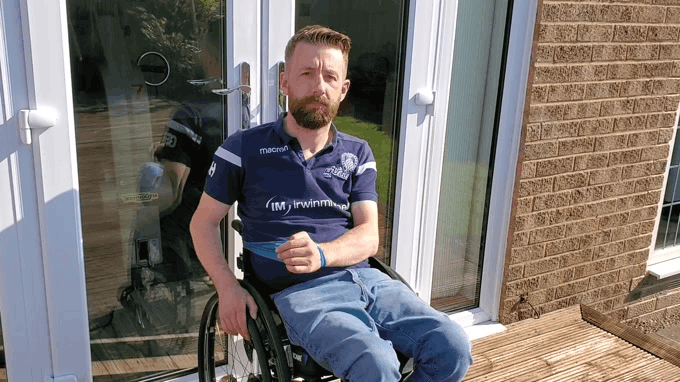 a gif of Gareth using a resistance band to do an external rotation exercise