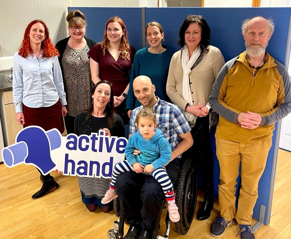 The Active Hands team smile in the office